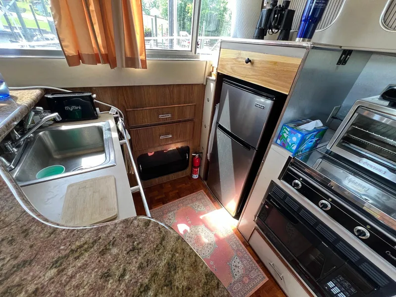 Slide: The Image of 1986 Chris-Craft 381 Catalina kitchen with sink, fridge, oven, and countertop appliances. - 15