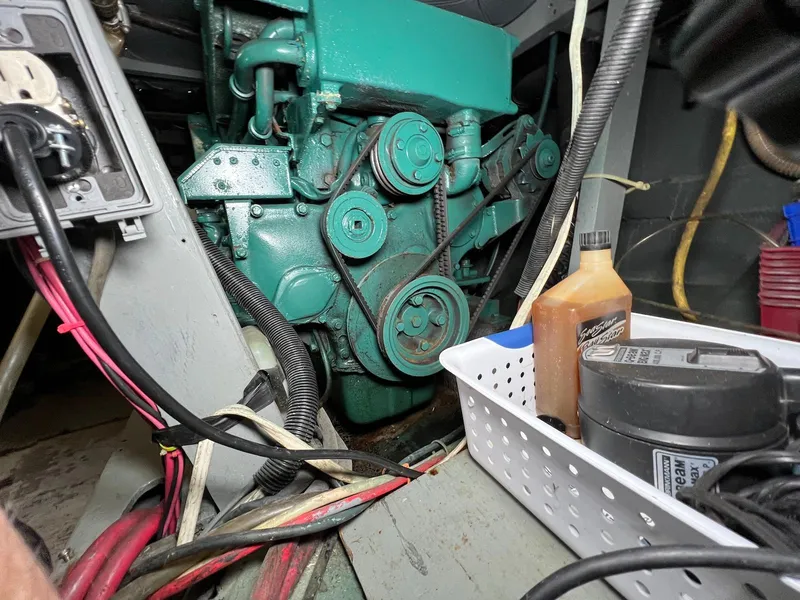 Slide: The Image of Engine compartment of a 1986 Chris-Craft 381 Catalina with visible wiring and maintenance supplies. - 28