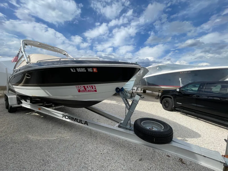Slide: The Image of 2012 Formula 270 Bowrider boat on trailer, for sale, under a partly cloudy sky. - 1