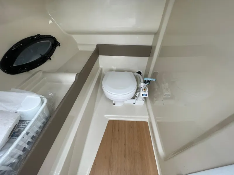 Slide: The Image of Interior of 2012 Formula 270 Bowrider boat showing compact bathroom with toilet and porthole. - 25