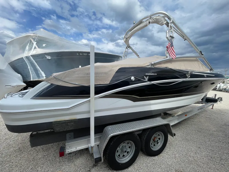 Slide: The Image of 2012 Formula 270 Bowrider boat on trailer, black and white design, under cloudy sky. - 3