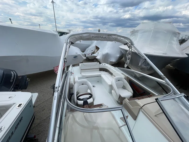 Slide: The Image of 2012 Formula 270 Bowrider boat with sleek design and spacious seating, docked outdoors. - 43