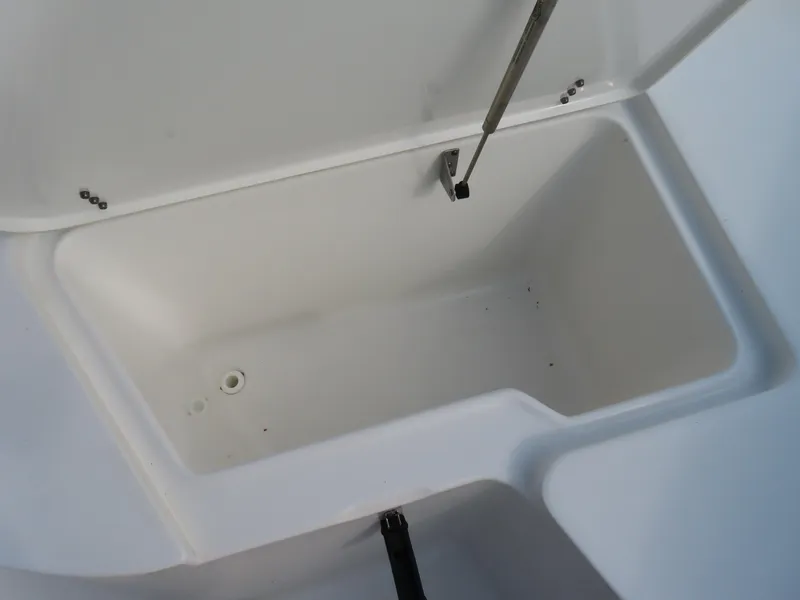 Slide: The Image of Storage compartment of 2021 Sea Hunt Ultra 234 boat, open lid, white interior. - 10