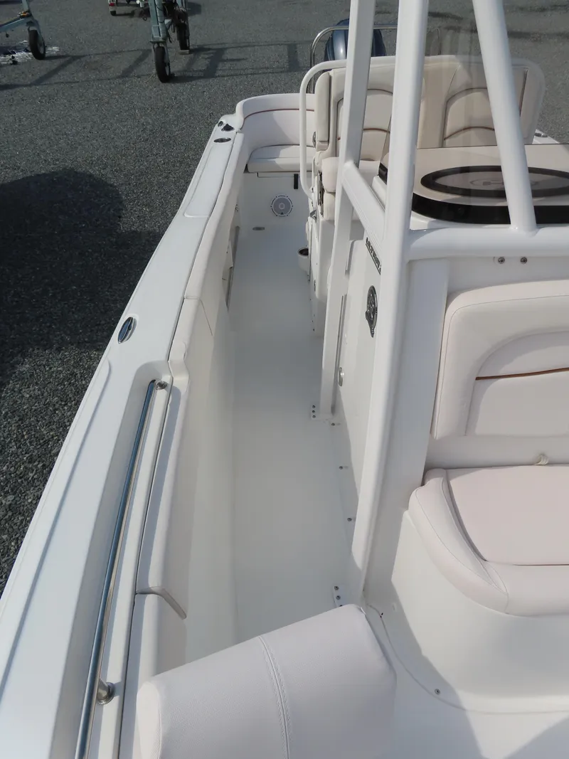 Slide: The Image of 2021 Sea Hunt Ultra 234 boat interior with white seating and spacious deck. - 15