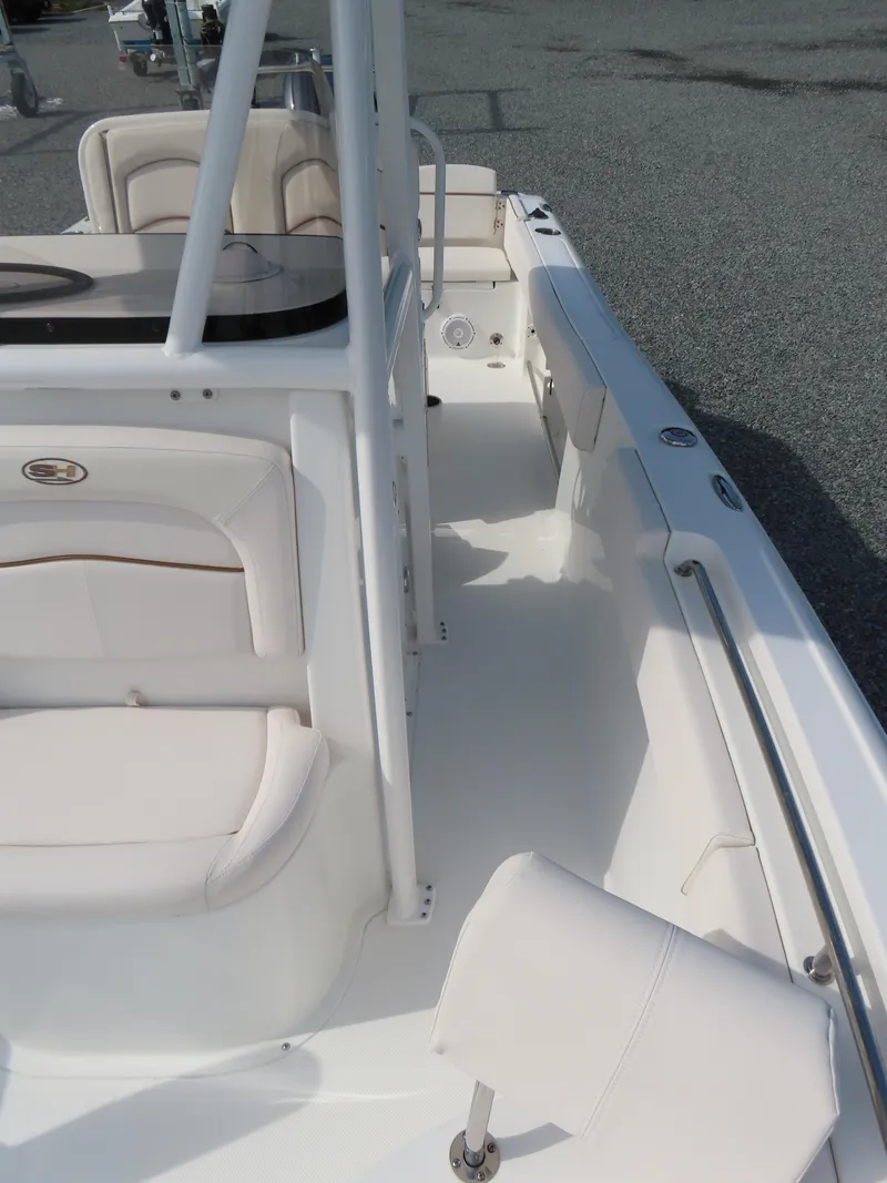 Slide: The Image of 2021 Sea Hunt Ultra 234 boat interior with white seating and spacious deck. - 16