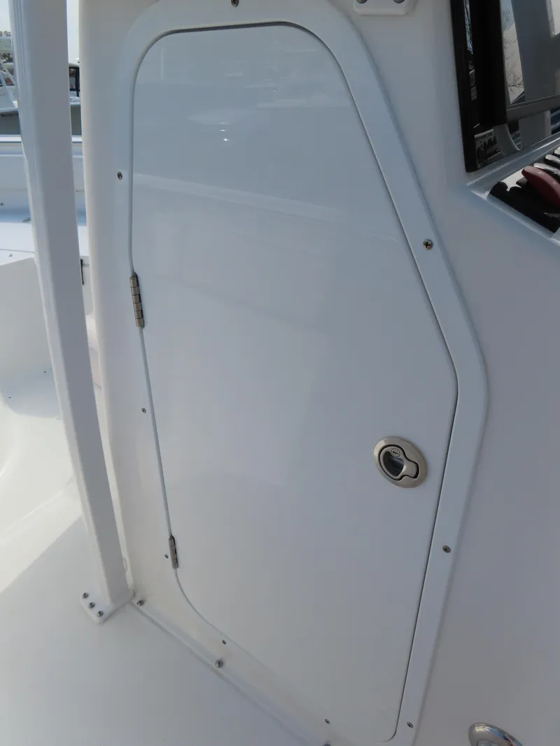 Slide: The Image of 2021 Sea Hunt Ultra 234 boat cabin door, white exterior, sleek design. - 19
