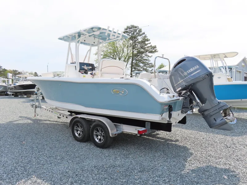 Slide: The Image of 2021 Sea Hunt Ultra 234 boat with Yamaha engine on trailer, parked outdoors. - 2
