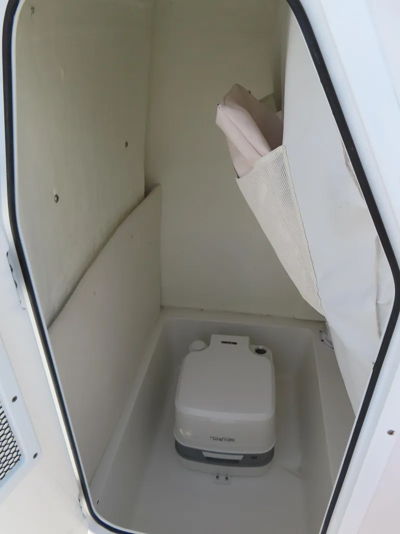 Slide: The Image of 2021 Sea Hunt Ultra 234 boat interior with portable toilet. - 20