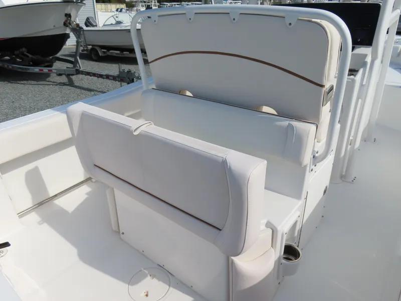 Slide: The Image of 2021 Sea Hunt Ultra 234 boat seating area with white cushioned seats and storage. - 31
