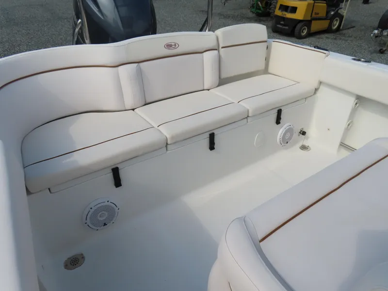 Slide: The Image of 2021 Sea Hunt Ultra 234 boat interior with cushioned seating and speakers. - 33