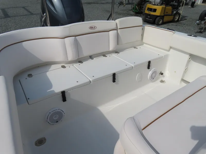 Slide: The Image of 2021 Sea Hunt Ultra 234 boat interior with white seating and storage compartments. - 34