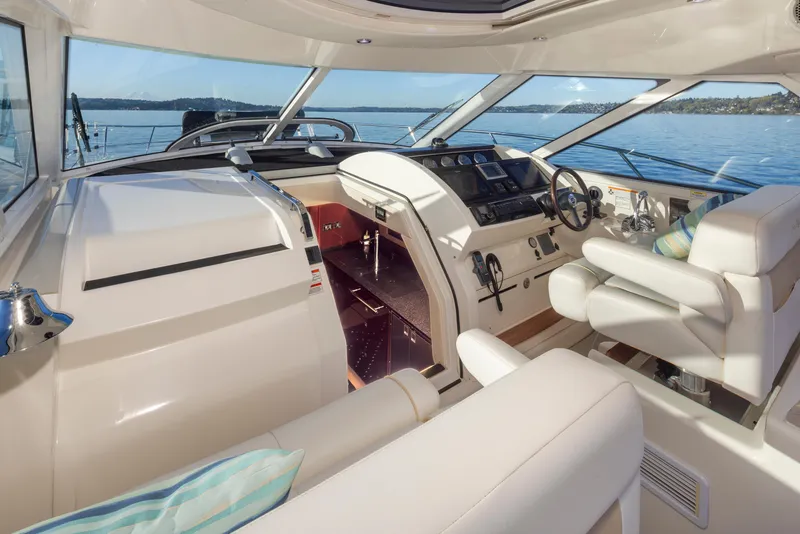 Slide: The Image of Luxurious 2010 Sea Ray Sundancer yacht interior with helm, plush seating, and scenic water view. - 13
