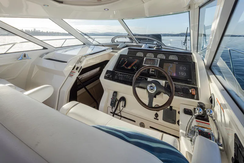 Slide: The Image of 2010 Sea Ray Sundancer helm with modern navigation equipment and panoramic water views. - 14