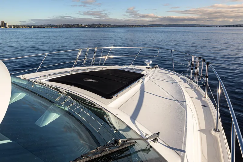 Slide: The Image of 2010 Sea Ray Sundancer yacht on calm water with clear sky and distant shoreline. - 16