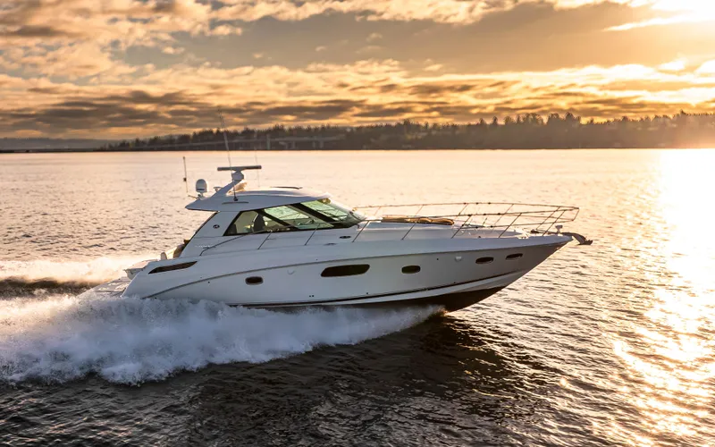 Slide: The Image of 2010 Sea Ray Sundancer cruising on a serene lake at sunset. - 22