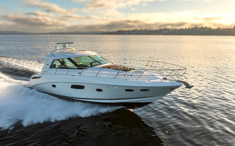 Slide: The Image of 2010 Sea Ray Sundancer yacht cruising on calm waters at sunset. - 23