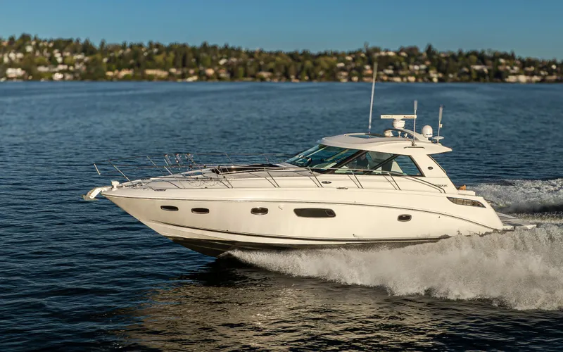 Slide: The Image of 2010 Sea Ray Sundancer cruising on a serene lake with scenic background. - 25