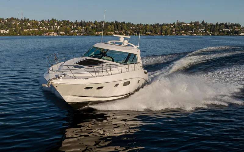 Slide: The Image of 2010 Sea Ray Sundancer cruising on a serene lake with scenic shoreline. - 26