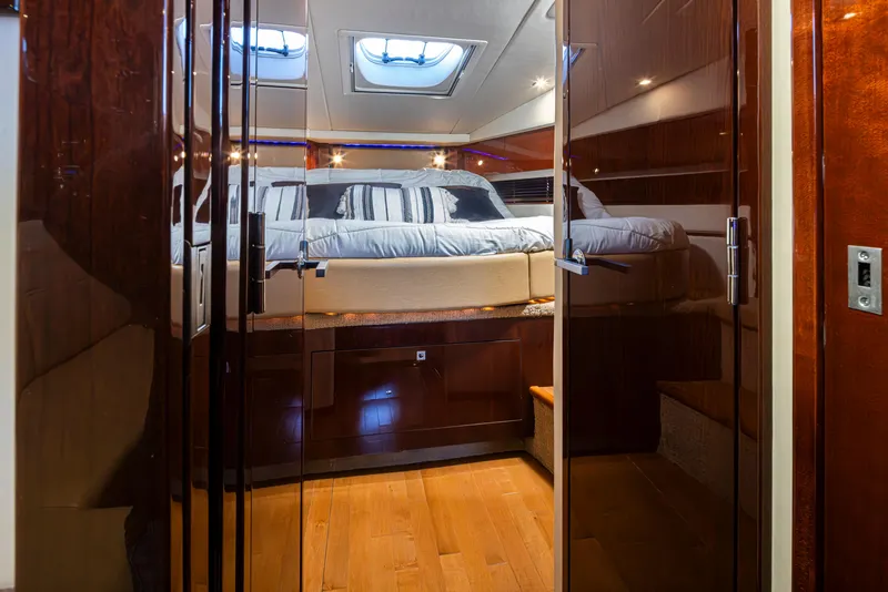 Slide: The Image of Luxurious 2010 Sea Ray Sundancer cabin interior with elegant wood finishes and cozy bedding. - 39