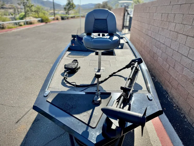 Slide: The Image of 2024 Tracker Pro 170 boat with a swivel seat and trolling motor on a sunny day. - 11