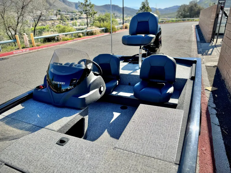 Slide: The Image of 2024 Tracker Pro 170 boat with seating, console, and scenic background. - 16