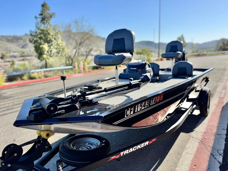 Slide: The Image of 2024 Tracker Pro 170 boat on trailer, parked outdoors with scenic background. - 3
