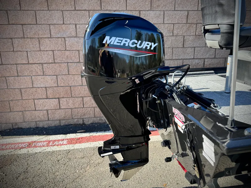 Slide: The Image of 2024 Tracker Pro 170 boat with Mercury outboard motor, parked on pavement. - 6