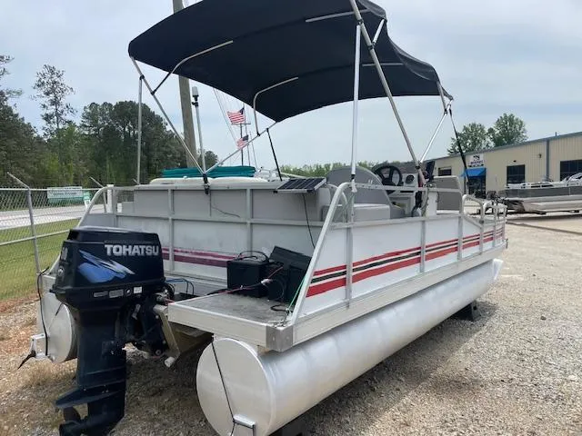 Slide: The Image of 1992 Leisure Island pontoon boat with Tohatsu motor and canopy, parked on gravel. - 5