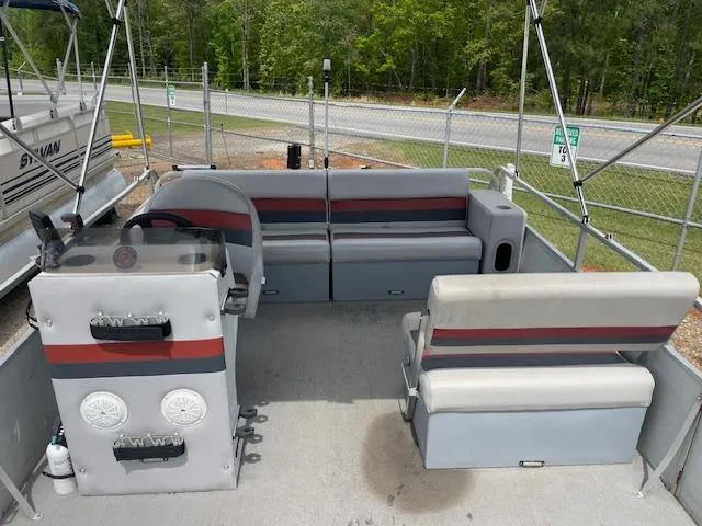 Slide: The Image of 1992 Leisure Island boat interior with gray and red seating, steering console, and outdoor setting. - 7