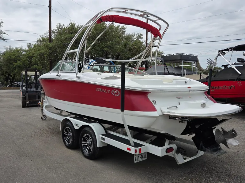 Slide: The Image of 2008 Cobalt 220 boat on trailer, red and white design, parked outdoors. - 2