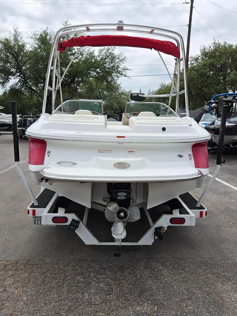 Slide: The Image of 2008 Cobalt 220 boat, rear view, white with red canopy, parked outdoors. - 3
