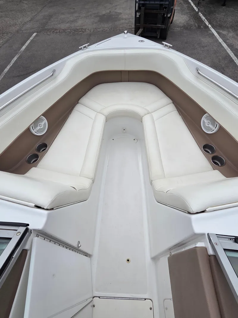 Slide: The Image of 2008 Cobalt 220 boat interior with white and tan seating, cup holders, and speakers. - 9