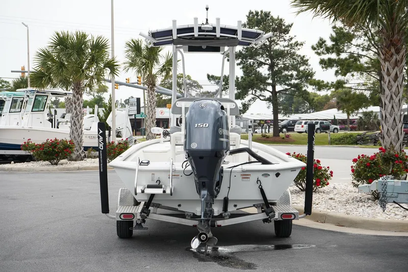 Slide: The Image of 2022 Avid 21 FS boat with Yamaha 150 engine, parked outdoors near palm trees. - 4
