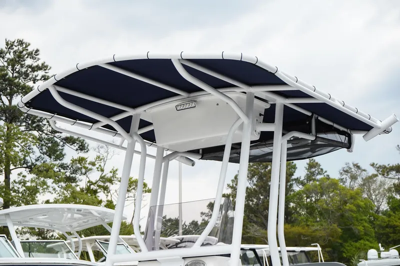 Slide: The Image of 2022 Avid 21 FS boat with a sleek T-top design against a cloudy sky. - 6