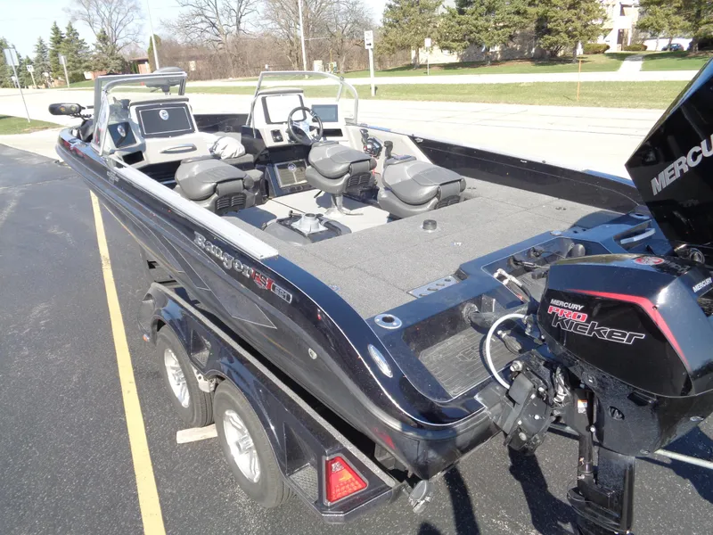 Slide: The Image of 2023 Ranger 621FS Pro fishing boat with Mercury Pro Kicker engine, parked on a trailer. - 17