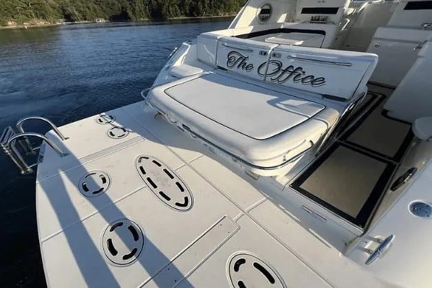 Slide: The Image of 2010 Sea Ray 450 Sundancer yacht with "The Office" name, docked on serene water. - 10