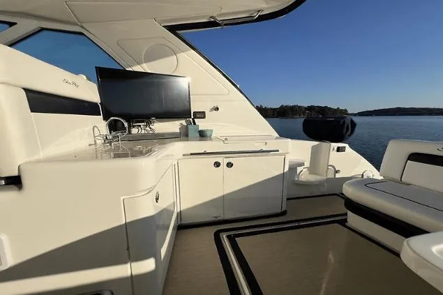 Slide: The Image of Luxurious 2010 Sea Ray 450 Sundancer yacht interior with kitchenette and scenic water view. - 17