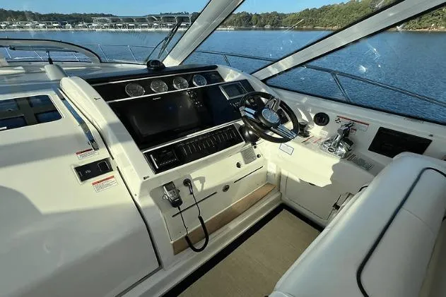 Slide: The Image of 2010 Sea Ray 450 Sundancer helm with modern controls and panoramic water view. - 28