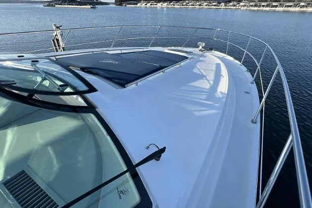 Slide: The Image of 2010 Sea Ray 450 Sundancer yacht on calm water, showcasing sleek deck design. - 35
