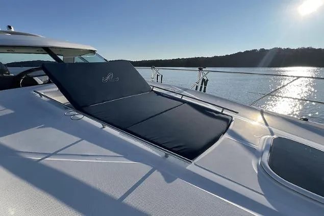 Slide: The Image of 2010 Sea Ray 450 Sundancer yacht with sun pad, on calm water, under clear sky. - 37