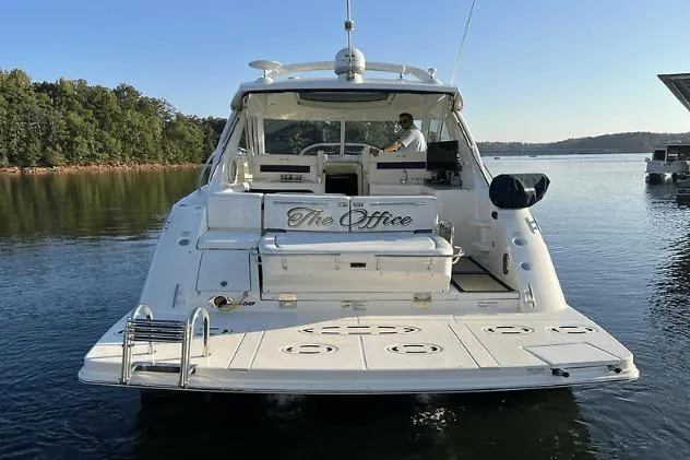 Slide: The Image of 2010 Sea Ray 450 Sundancer yacht named "The Office" on a serene lake. - 4