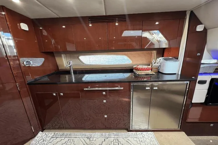 Slide: The Image of Luxurious kitchen interior of 2010 Sea Ray 450 Sundancer yacht with sleek cabinetry. - 43
