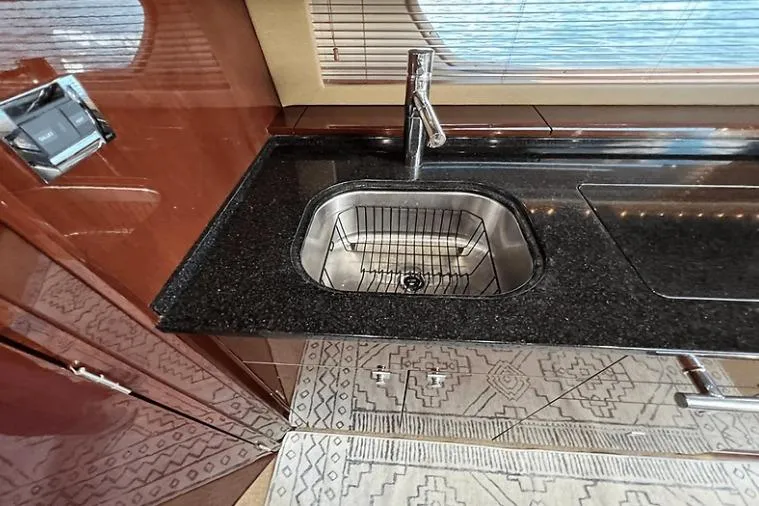 Slide: The Image of Luxurious kitchen sink area on 2010 Sea Ray 450 Sundancer yacht with sleek black countertop. - 46