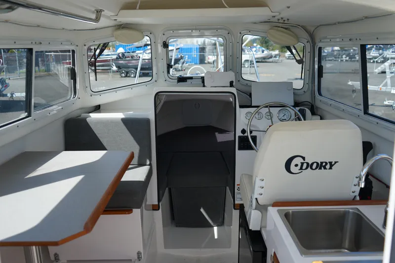 Slide: The Image of Interior of 2022 C-Dory 22' Cruiser boat with seating, table, and helm. - 10