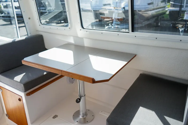 Slide: The Image of Interior of 2022 C-Dory 22' Cruiser with table and cushioned seating. - 12