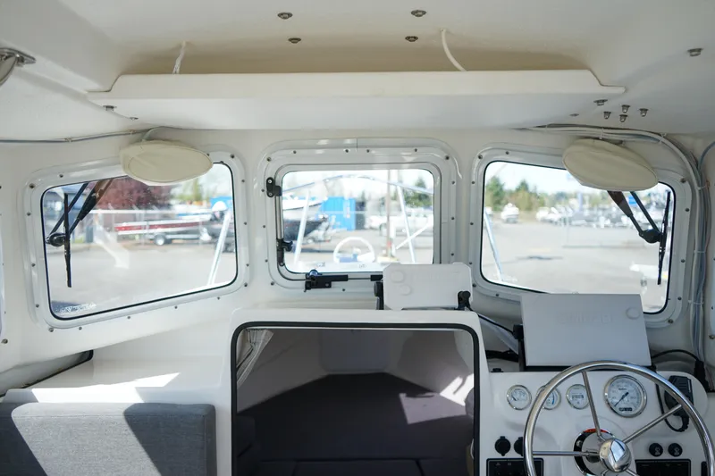 Slide: The Image of Interior of a 2022 C-Dory 22' Cruiser boat, featuring steering wheel and dashboard. - 13