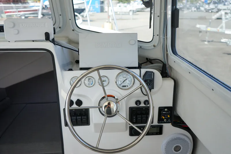 Slide: The Image of 2022 C-Dory 22' Cruiser helm with steering wheel and instrument panel. - 16