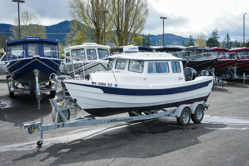 Slide: The Image of 2022 C-Dory 22' Cruiser on trailer in a boat dealership lot. - 22