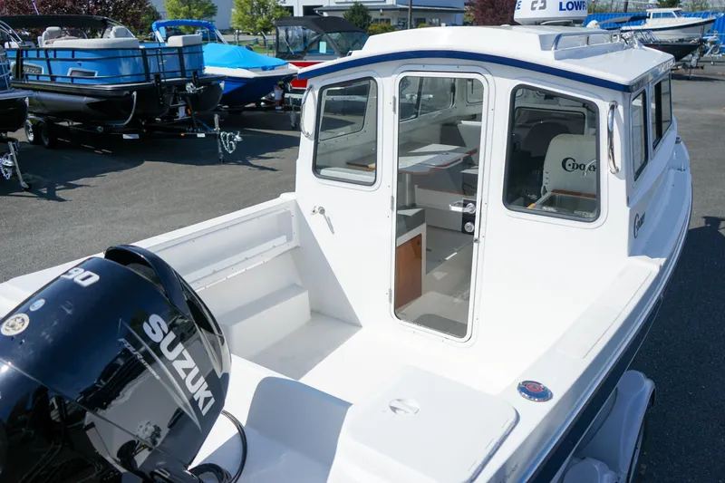 Slide: The Image of 2022 C-Dory 22' Cruiser with Suzuki engine, docked in a marina. - 6