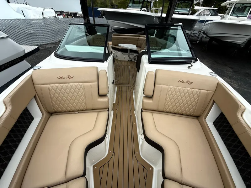 Slide: The Image of 2019 Sea Ray SLX 250 boat interior with tan leather seating and wood flooring. - 14